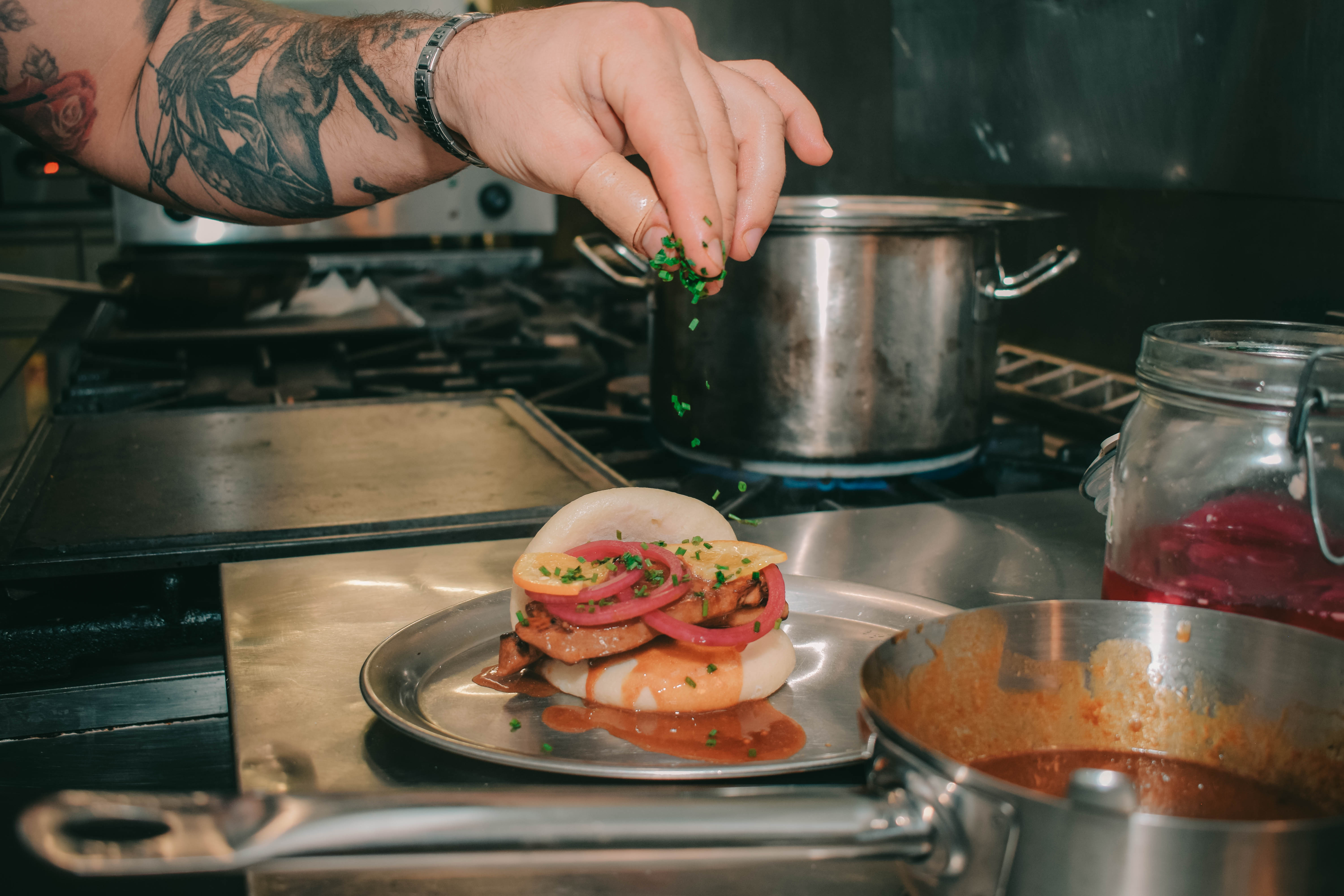 Bao-Brötchen mit karamellisiertem Schweinebauch, Teriyaki-Sauce und eingelegter roter Zwiebel